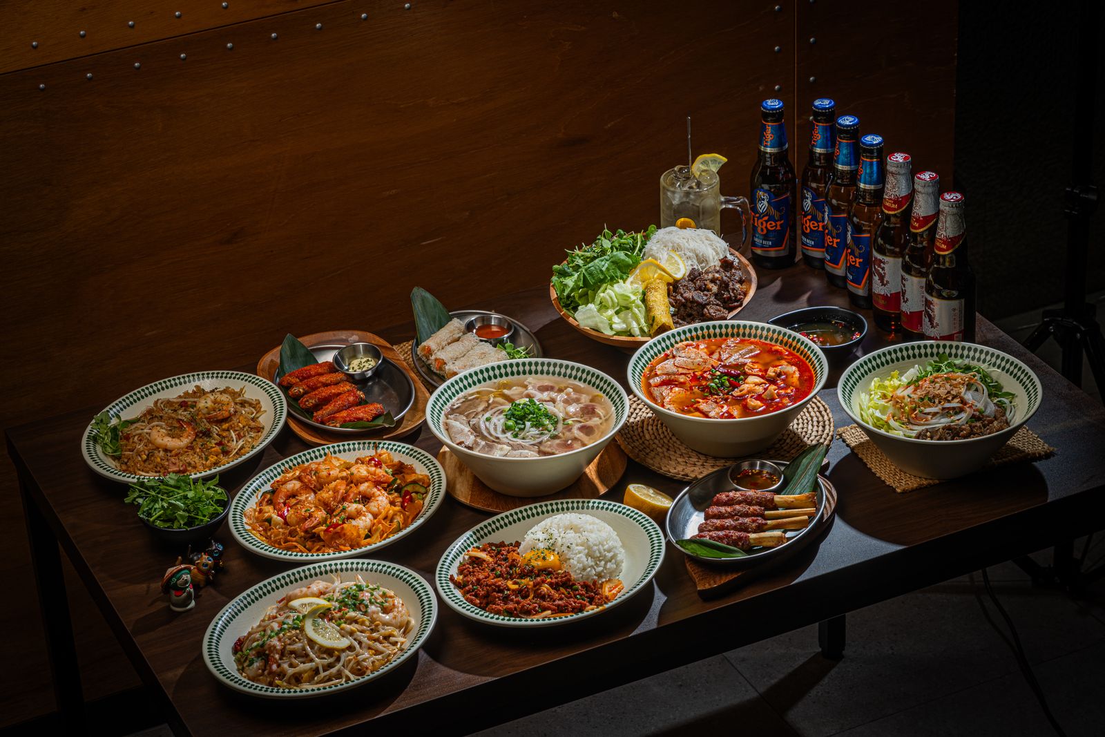 여러 아시안 요리와 맥주병이 놓인 저녁 테이블