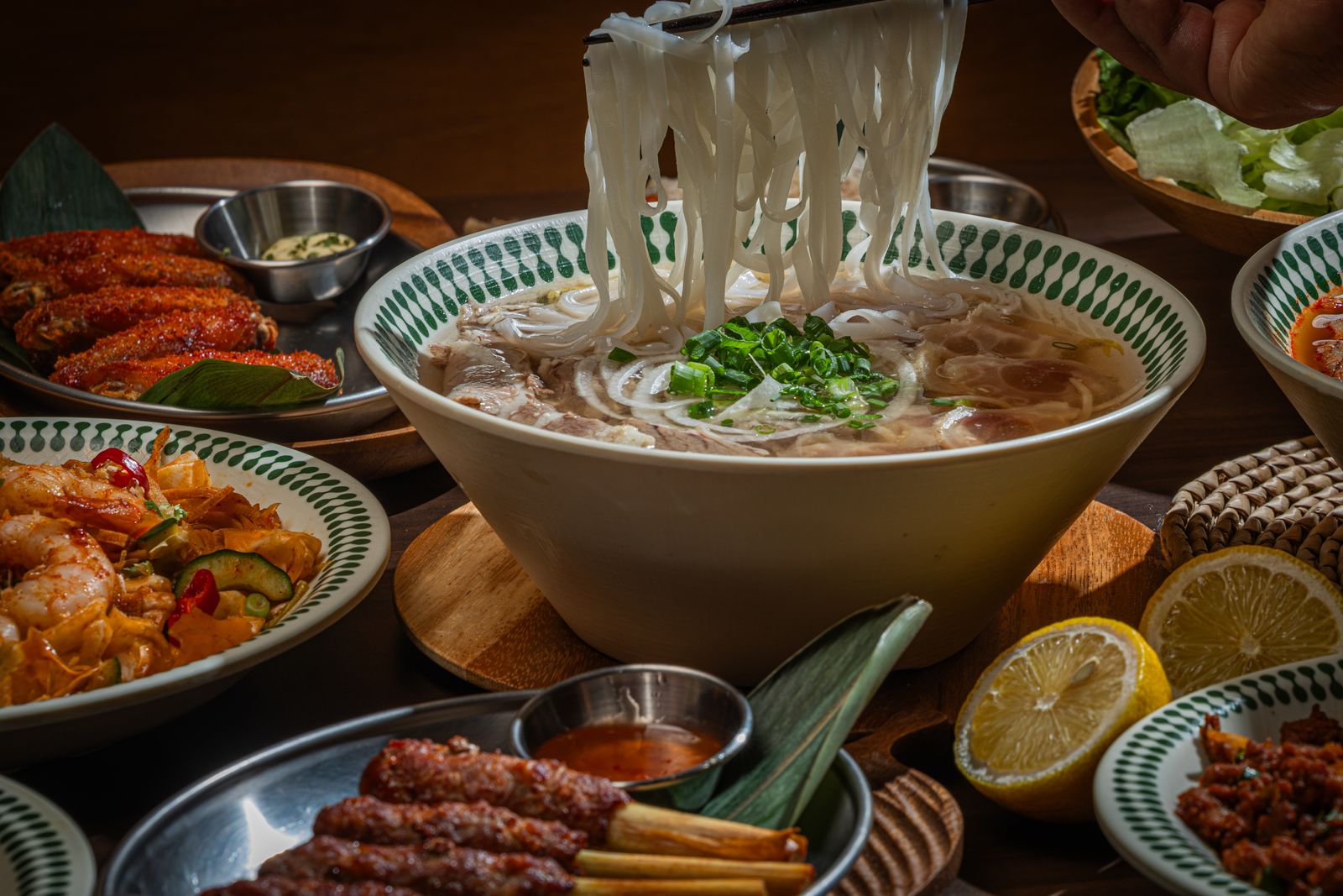 맑은 육수에서 쌀국수 면을 젓가락으로 들어 올리는 모습